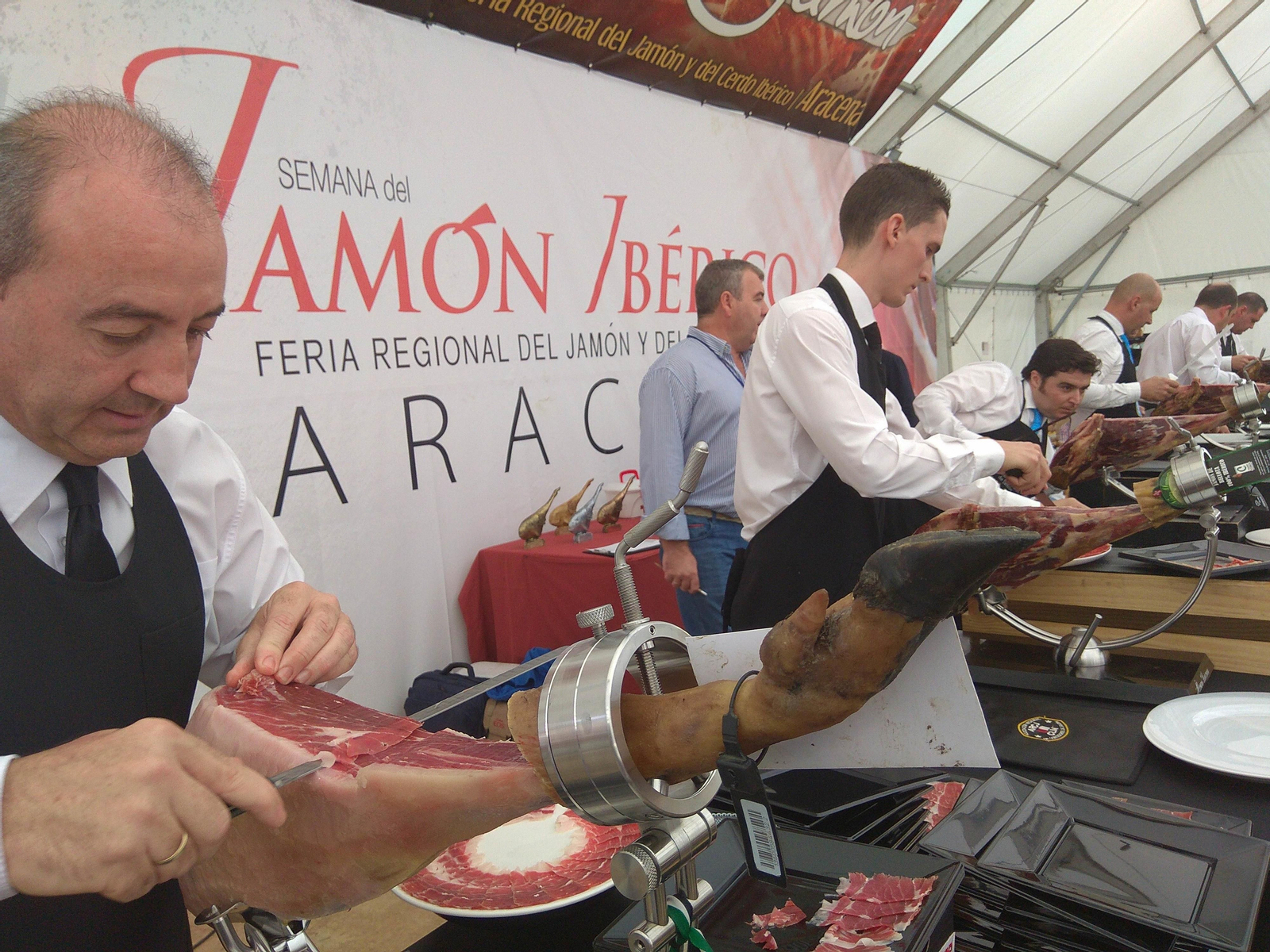 Cortadores de jamón en una de las carpas de la feria.