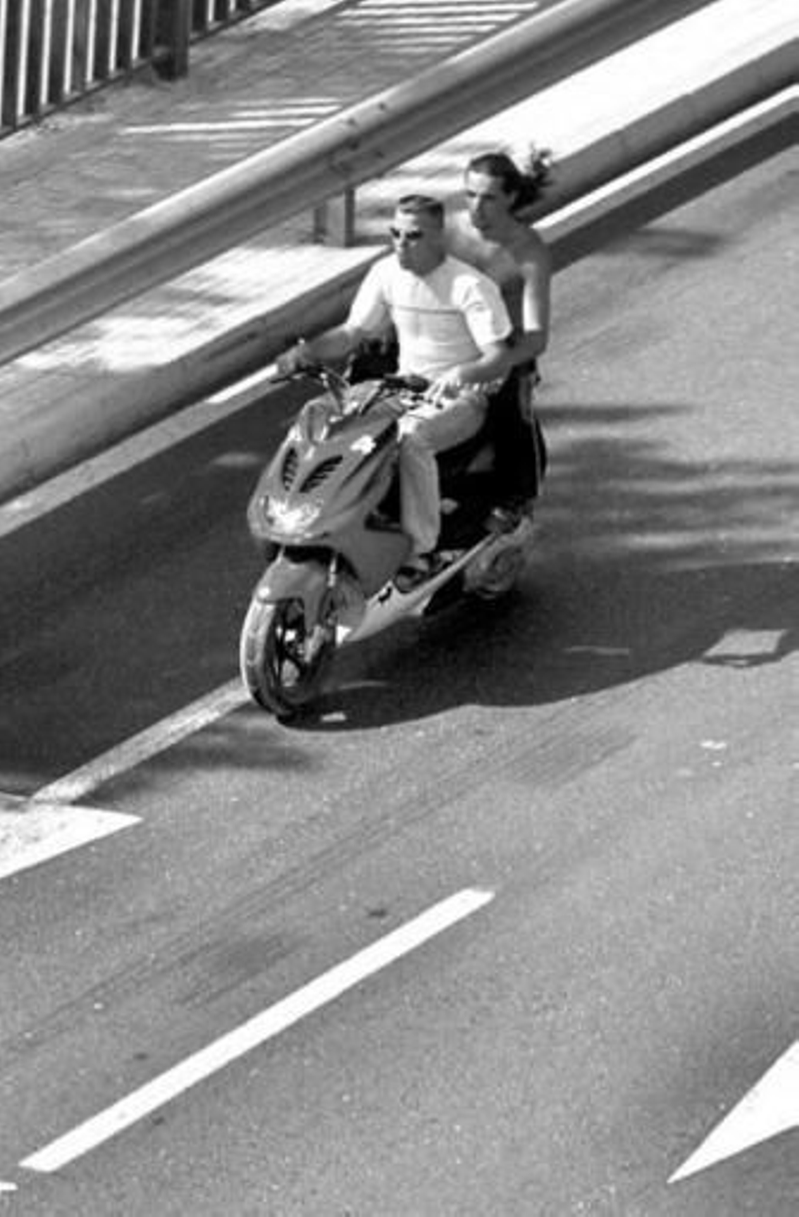 Dos jóvenes circulan sin casco en un ciclomotor.