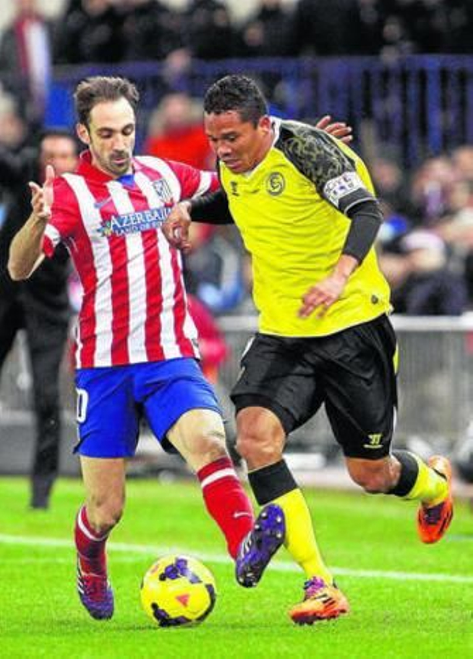 El sevillista Bacca es perseguido por el atlético Juanfran.