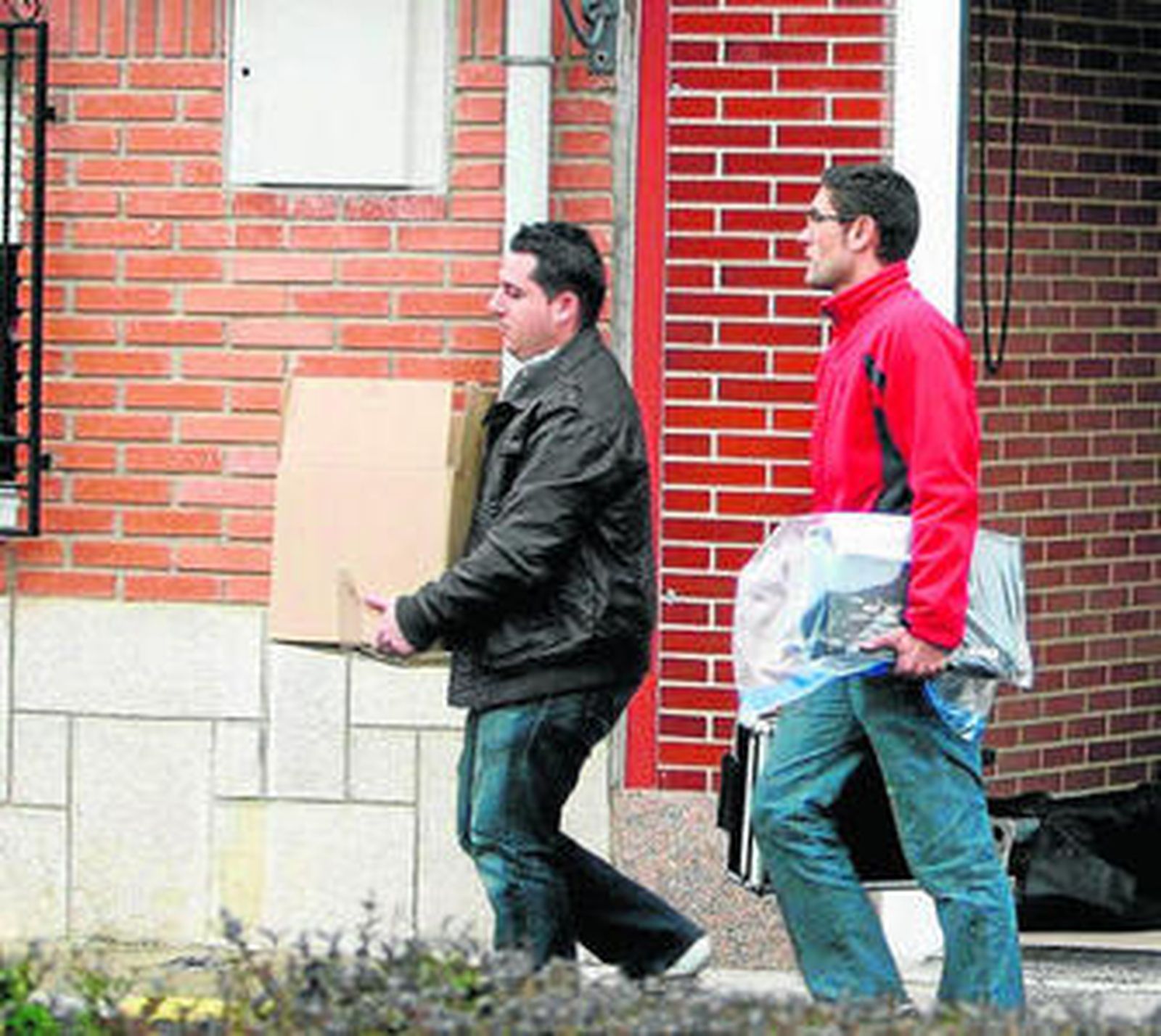 Policías sacando una caja y un ordenador de casa de Marta.