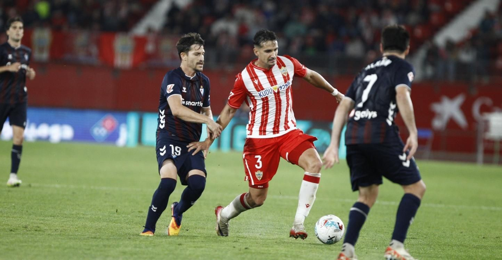 Álex Muñoz avanza ante la oposición de Toni Villa, con la presencia de Alkain por delante.