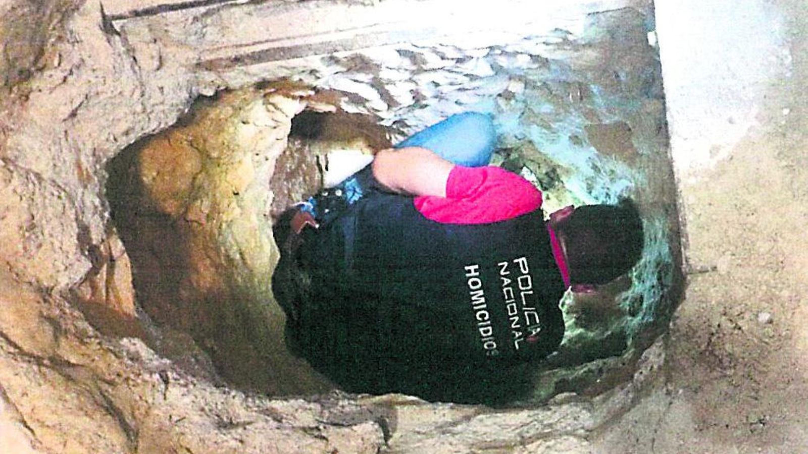 Un agente dentro del zulo donde fueron hallados los tres cadáveres.