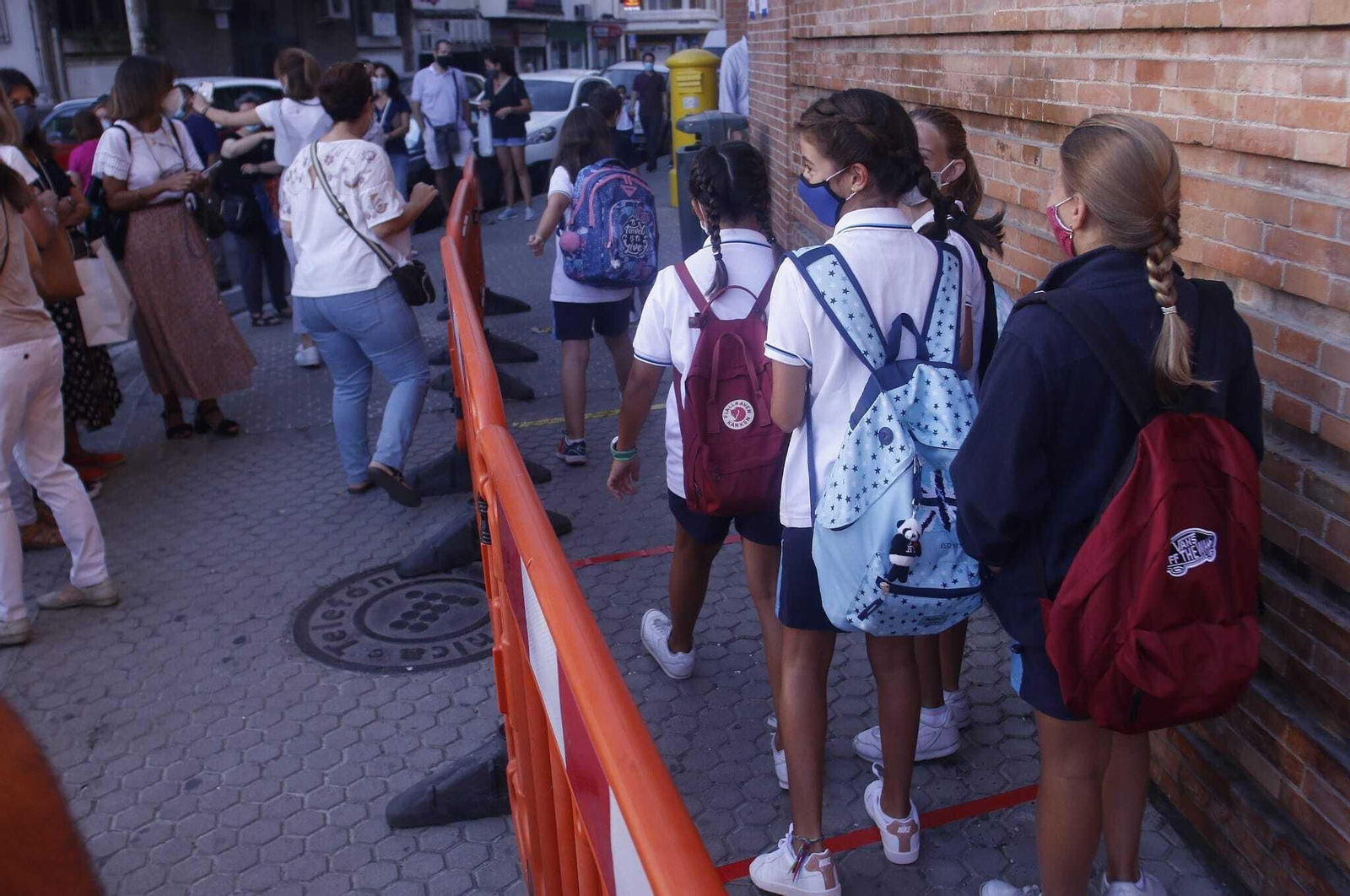Varios escolares esperan su turno para acceder a clase
