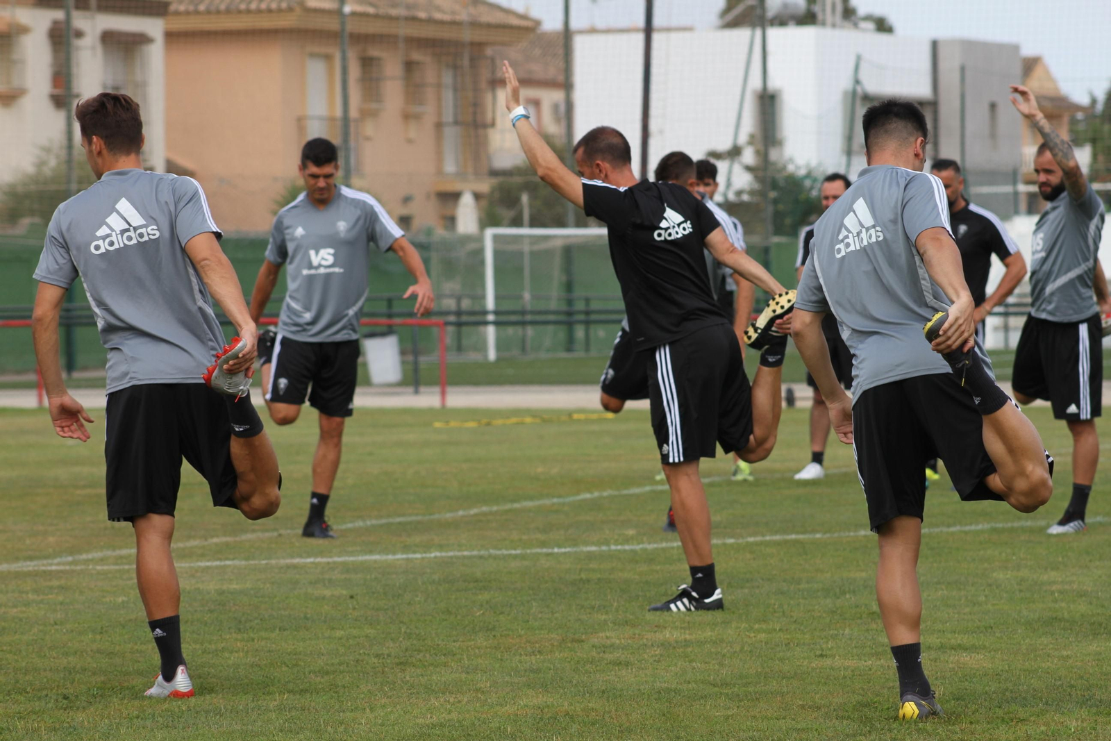 Los jugadores realizan estiramientos.