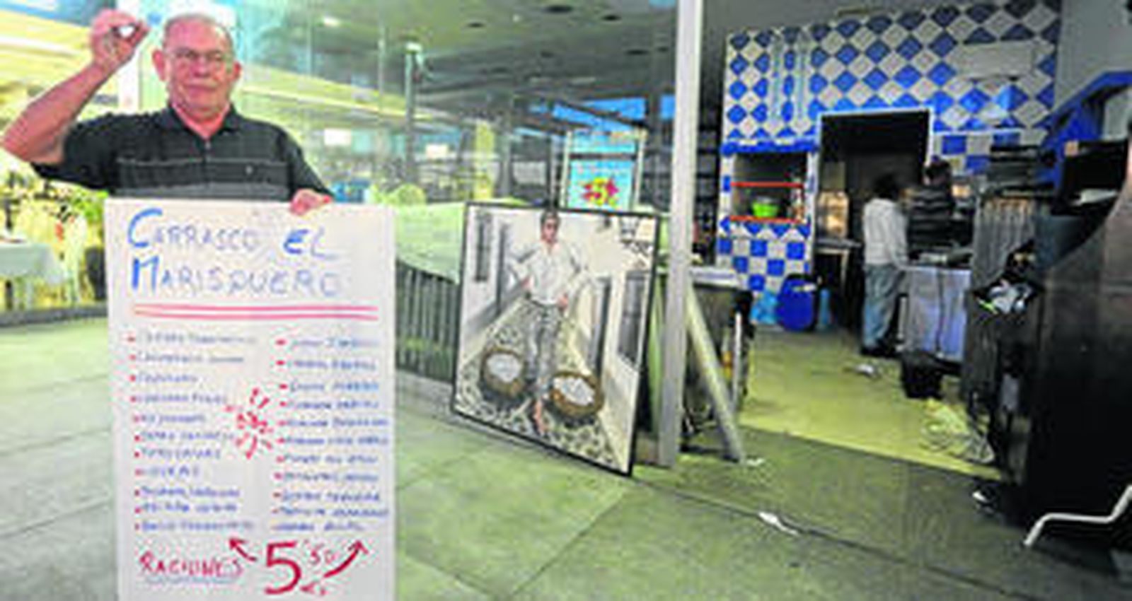 El propietario del Marisquero, ayer, recogiendo el material de su establecimiento.