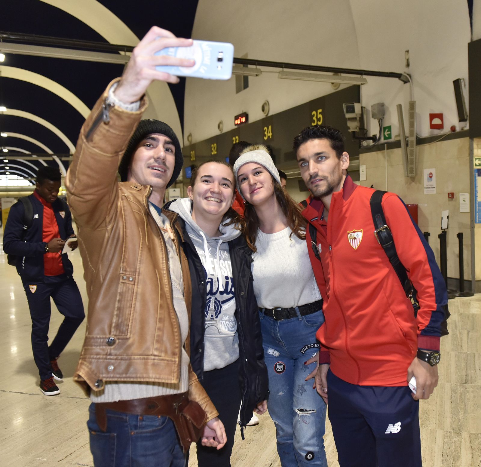 Jesús Navas se fotografía con tres aficionados antes de volar hacia Vitoria.