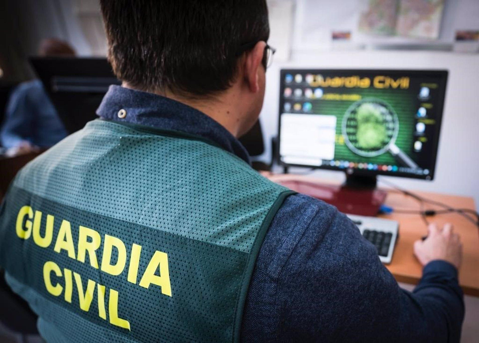 Un agente de la Guardia Civil con un ordenador.