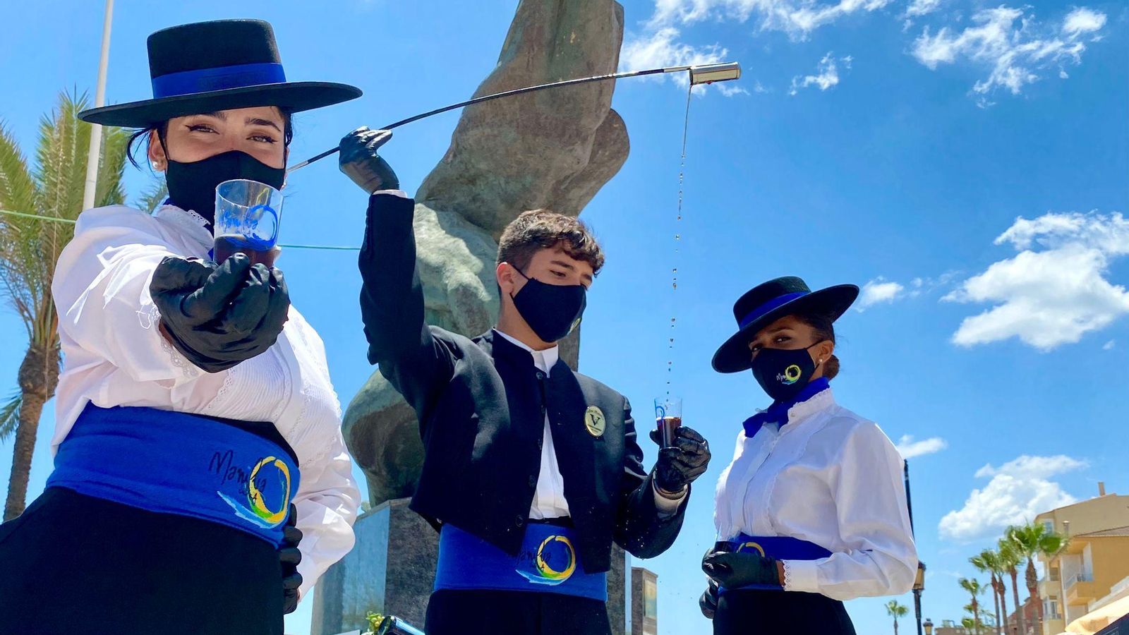 Jesús Rubiales Jr. venenciando sus primeras copas de vino en Manilva este miércoles junto a dos azafatas de Venenciadores SL..