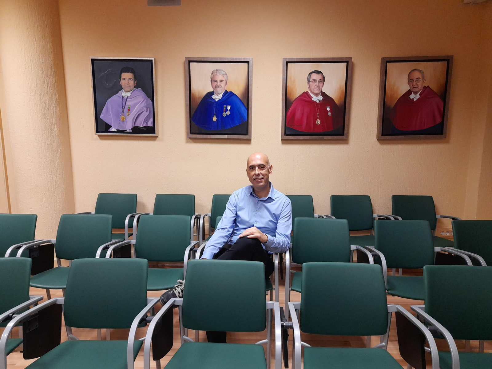 Francisco Díaz Bretones ante retratos de algunos de los que le precedieron en el Decanato de la Facultad de Relaciones Laborales y Recursos Humanos.