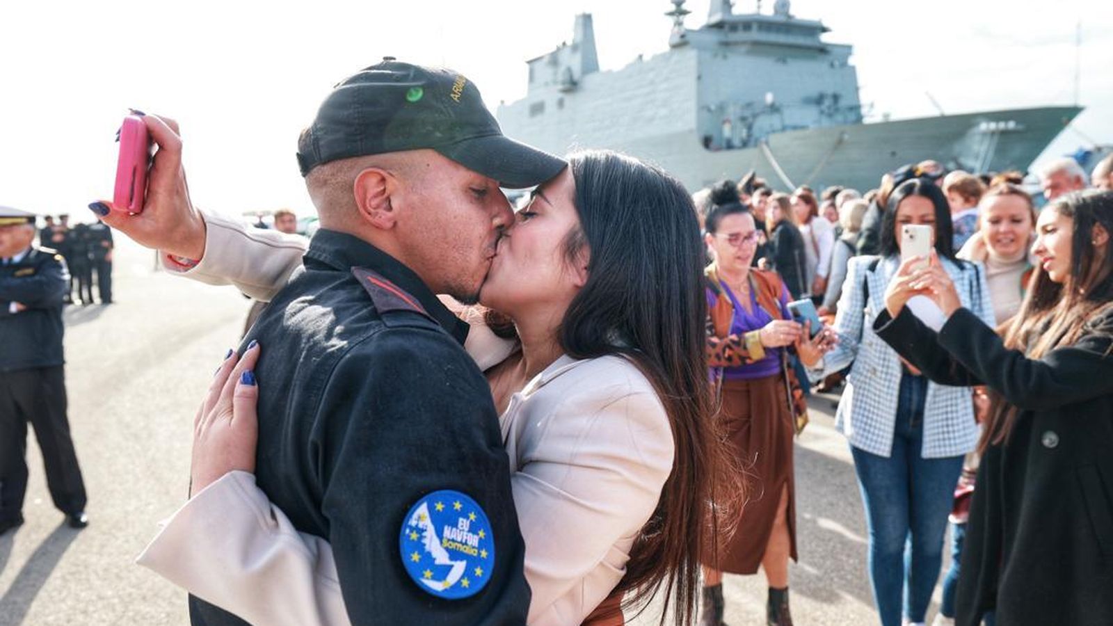 Una pareja se besa en la llegada.