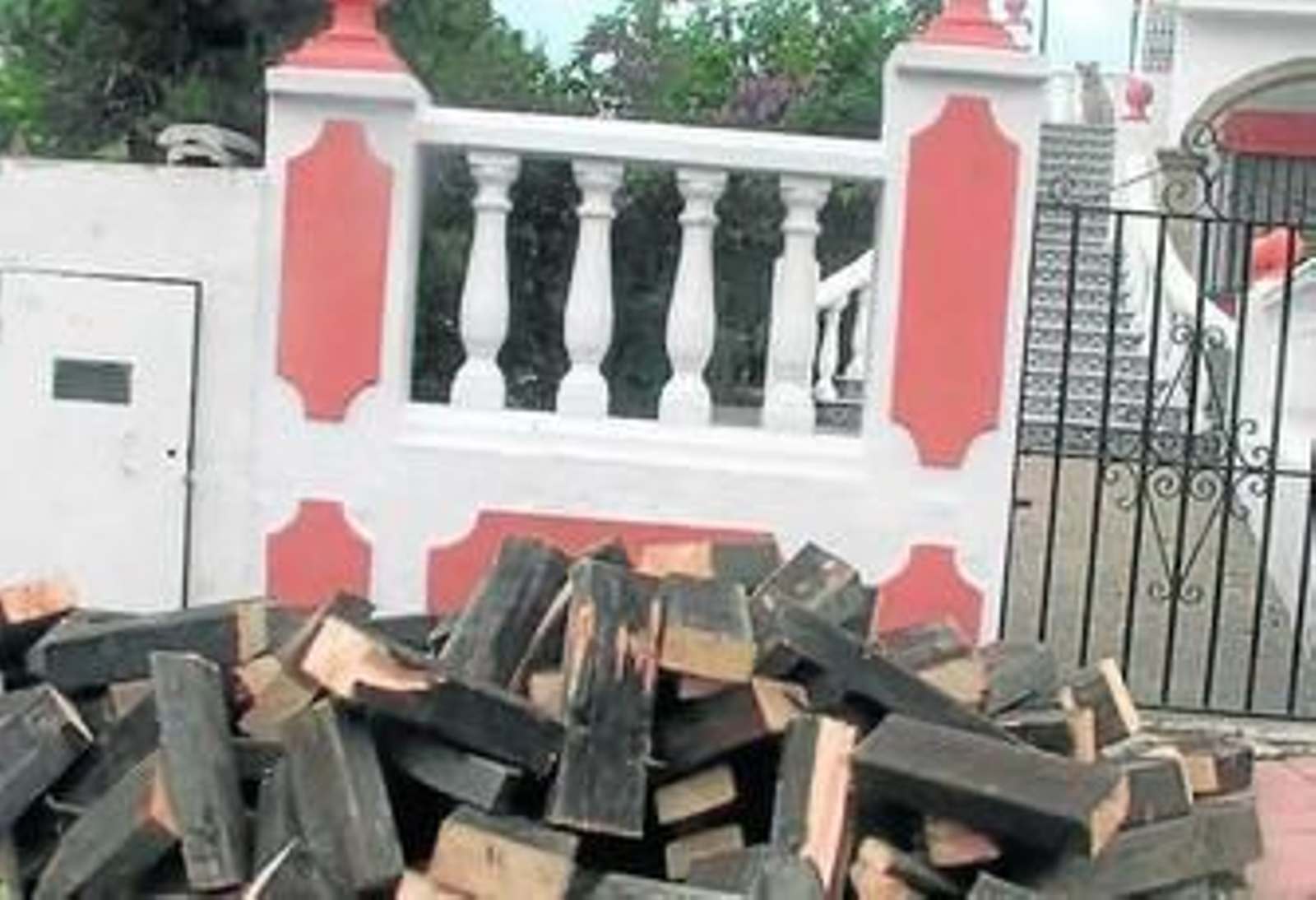 La madera de las pégolas apiladas a la entrada de la vivienda.