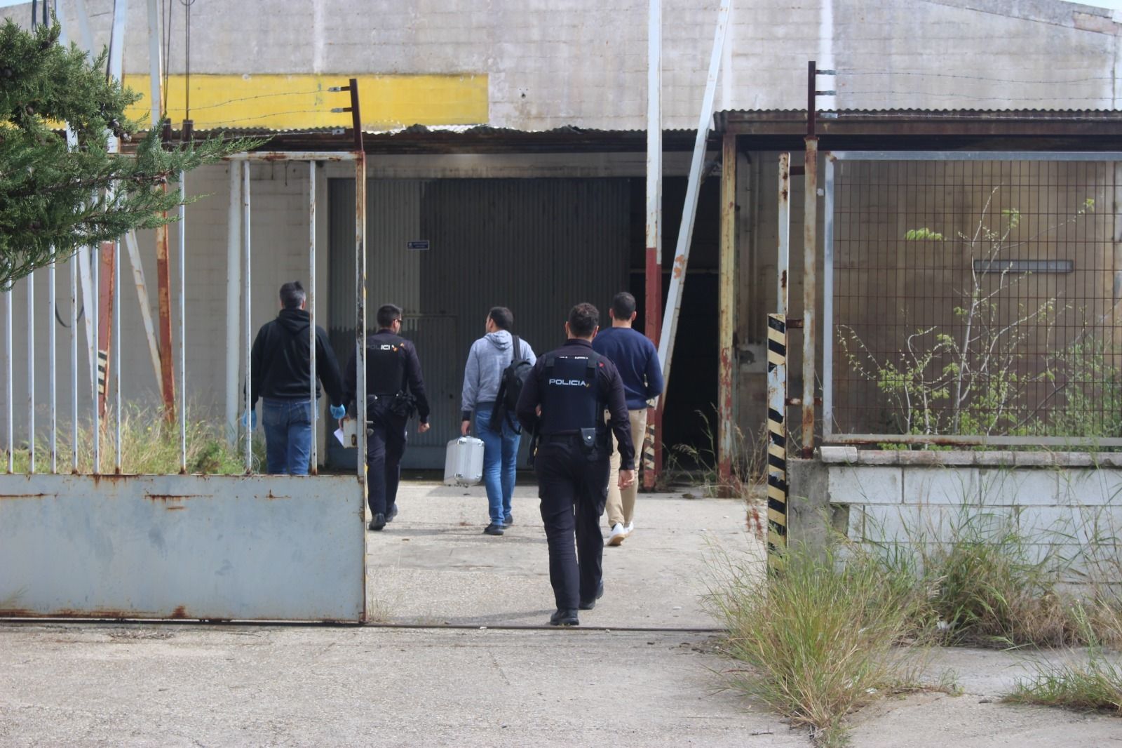 Agentes policiales entran en la nave donde apareció el cuerpo