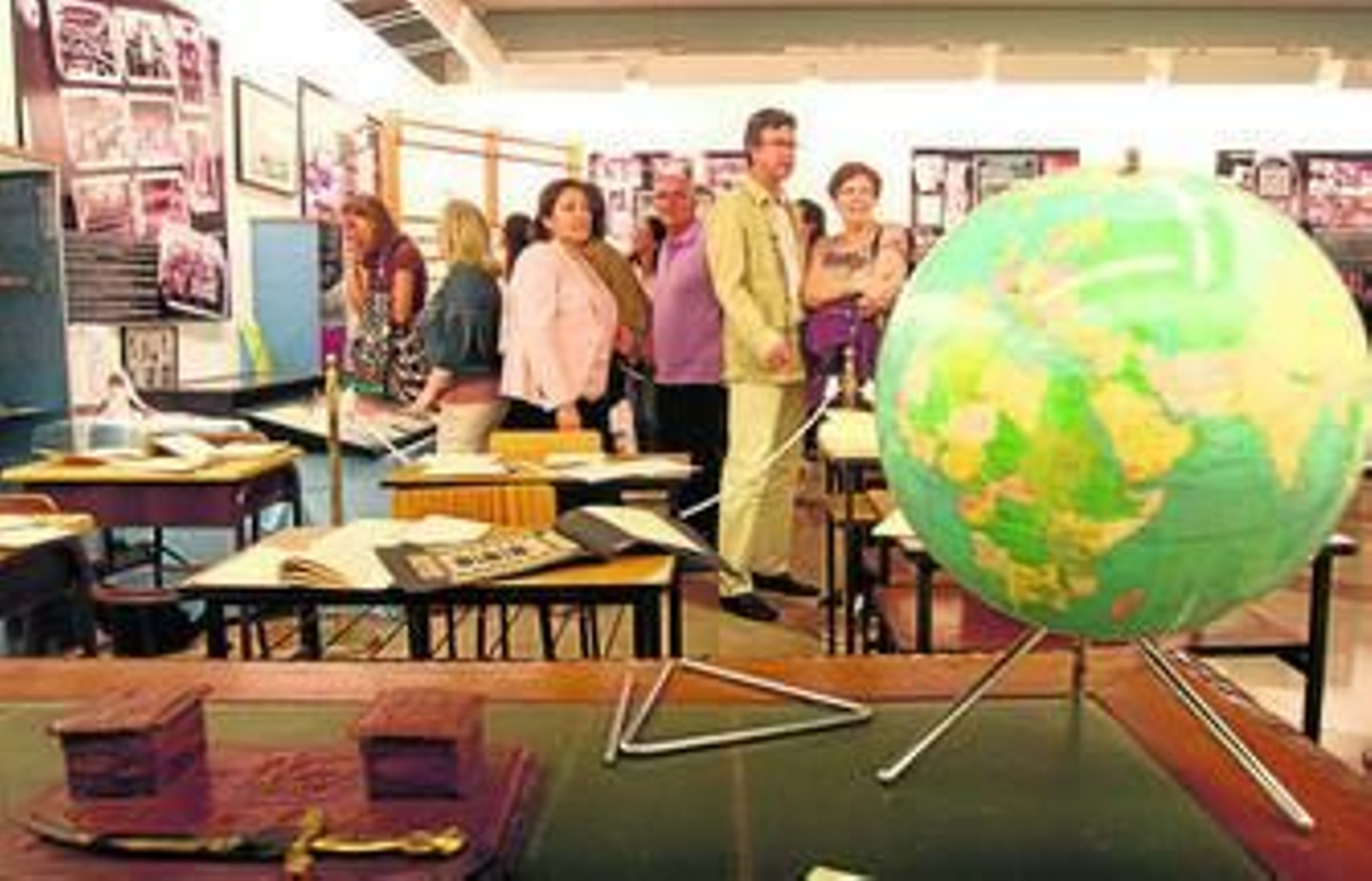 1. La reproducción de un aula de la primera mitad del siglo XX. 2. Vitrina con objetos relacionados con Santa Teresa de Jesús. 3. Una monja mira algunas de las fotografías expuestas. 4. El alcalde de Huelva, Pedro Rodríguez; el director del colegio, Francisco José Crespo, y la coordinadora de la comunidad Teresiana, María Isabel de Sande, ante el mural de Santa Teresa de Jesús y de San Enrique de Ossó.