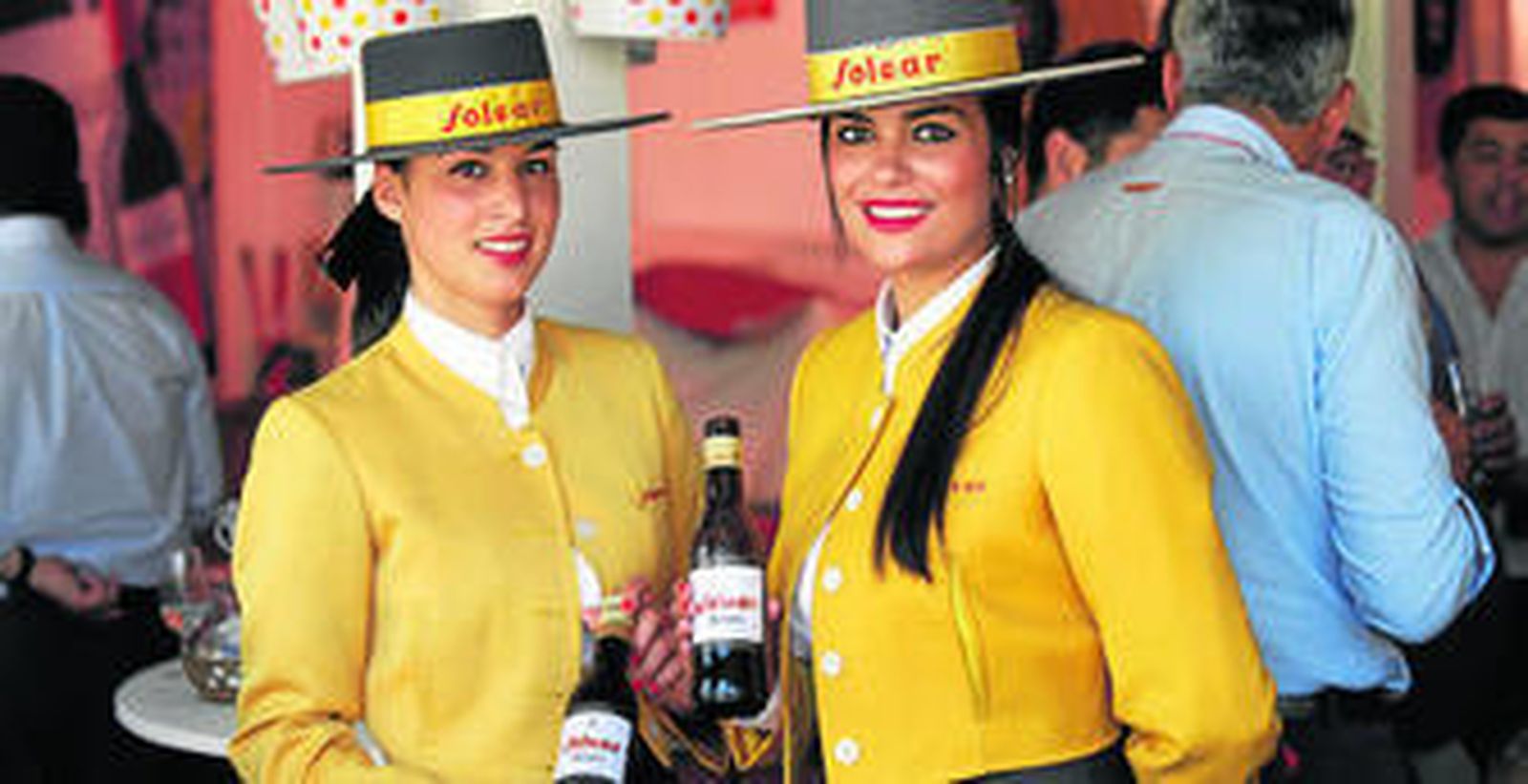 Dos azafatas de una conocida marca de manzanilla, en una de las casetas del recinto ferial.