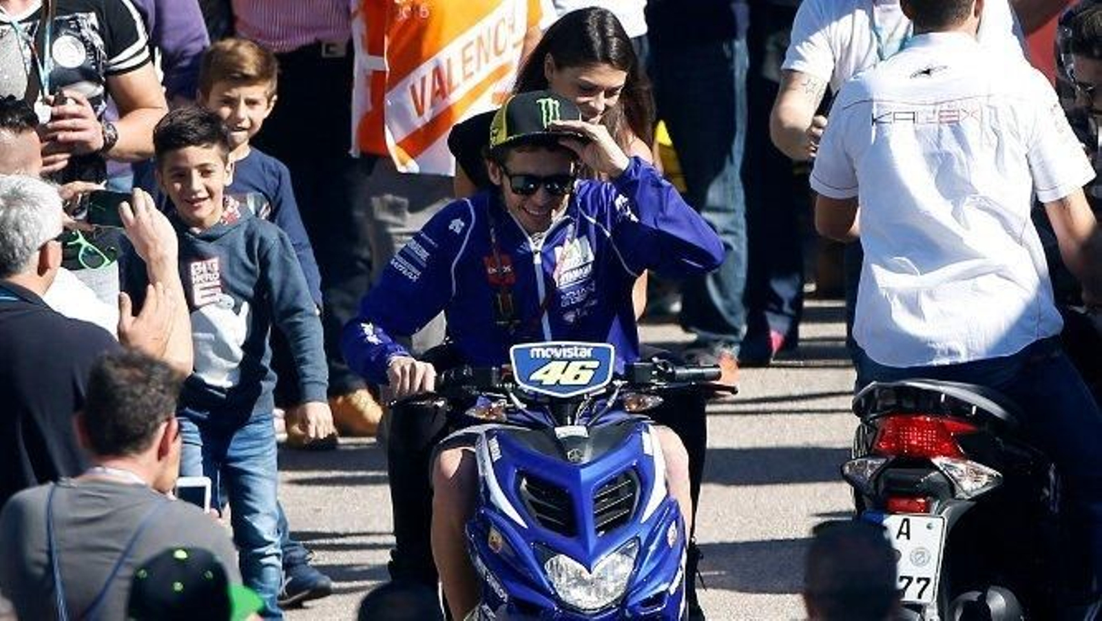 Rossi, abriéndose paso en el paddock de Valencia entre los aficionados.