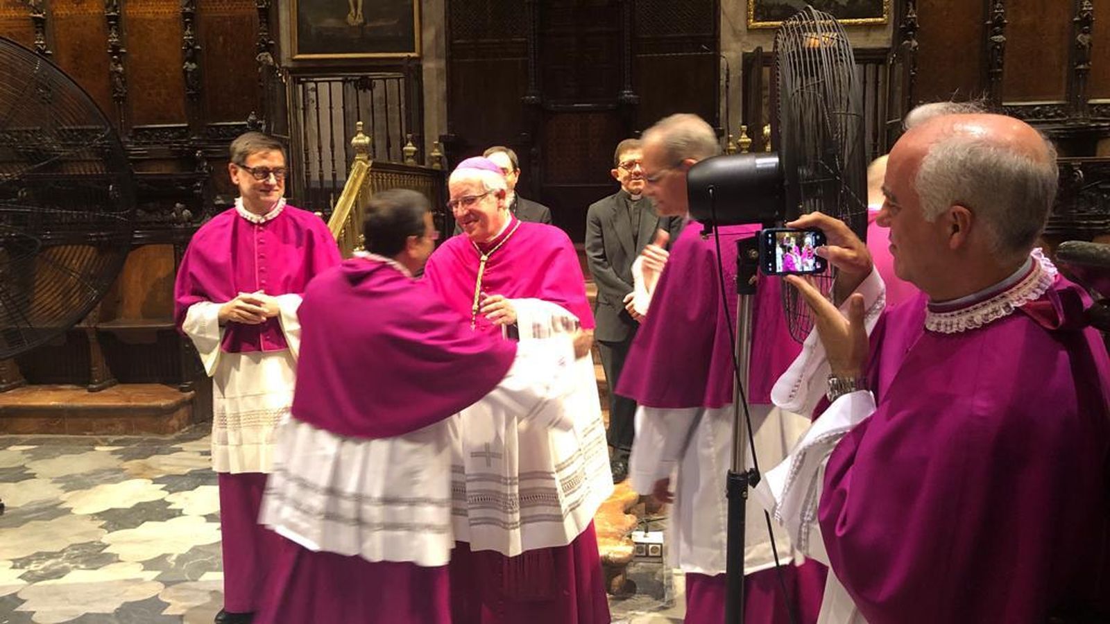 Los miembros del cabildo abrazan al nuevo deán y al arzobispo.