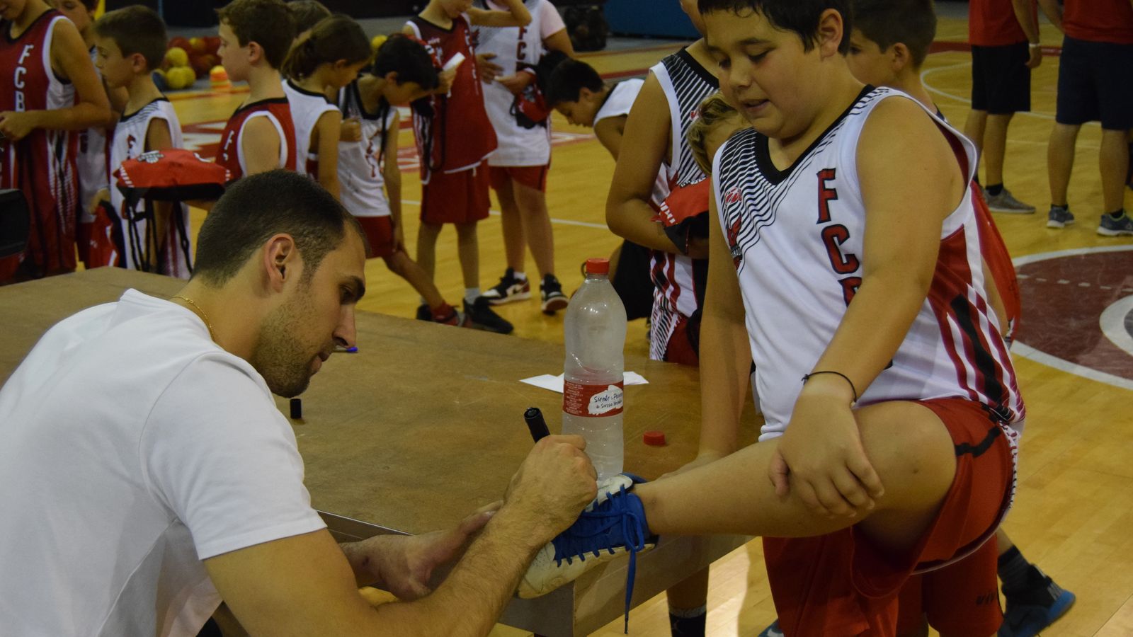 Pablo Aguilar firma en la zapatilla de un joven jugador