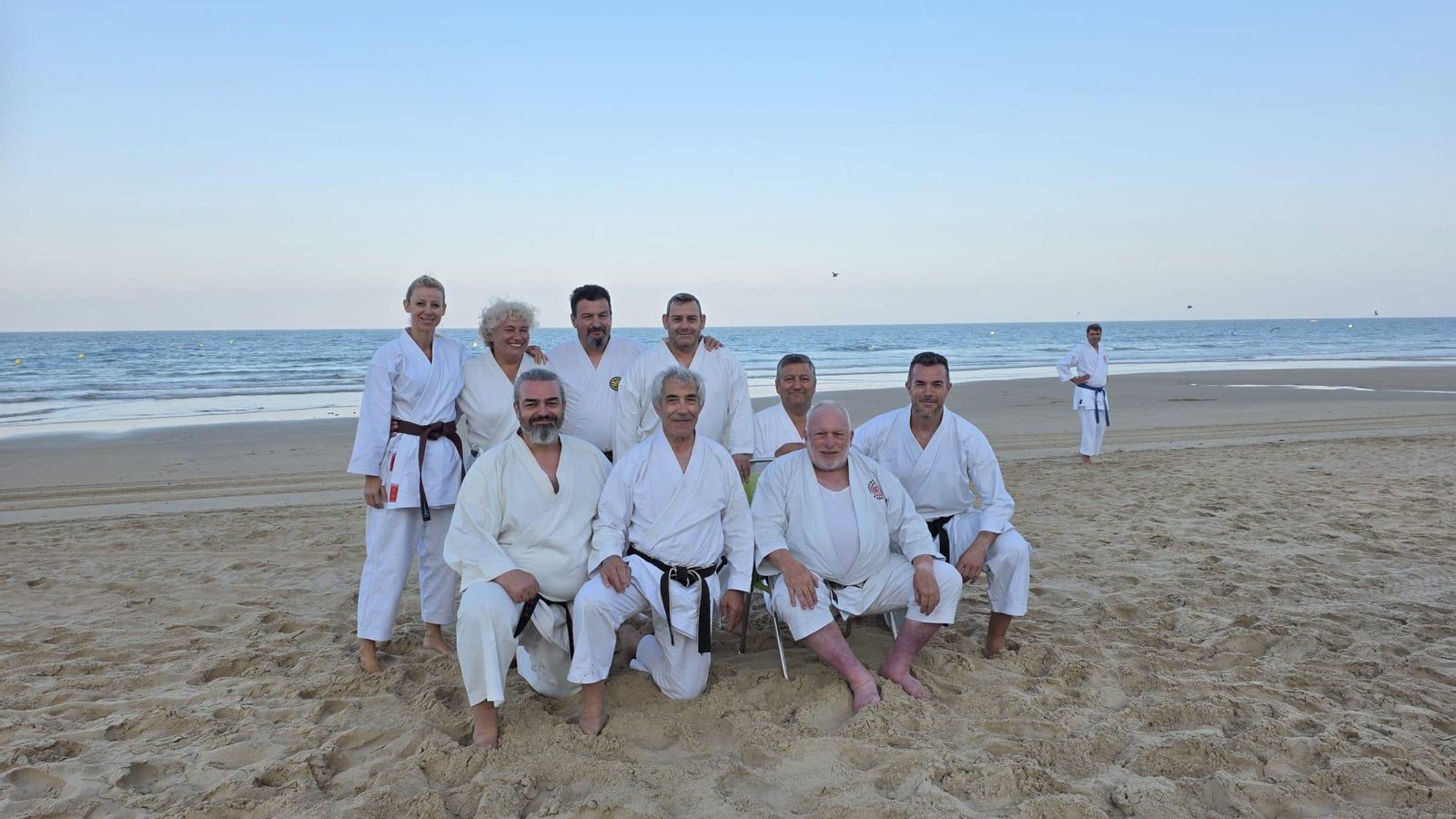 Una representación del club, en la playa junto a los maestros que impartieron el Curso Internacional en Cádiz.