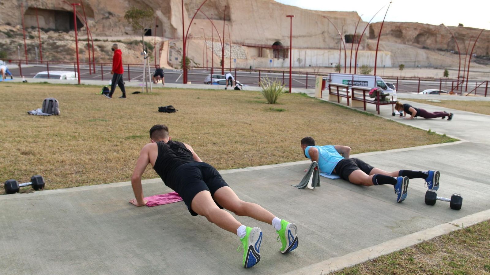 Pablo Sánchez, en el centro con las Cuevas de Conan al fondo, mientras sus deportistas hacen flexiones.
