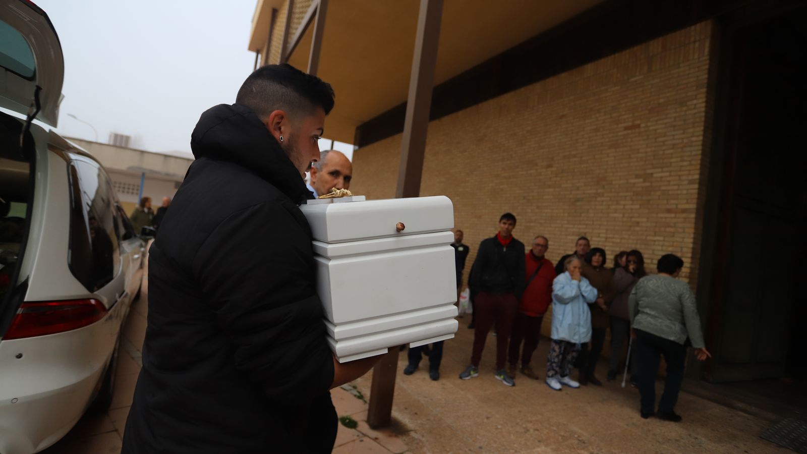 Un joven lleva el ataúd al interior del templo para el sepelio de La Hispanidad.