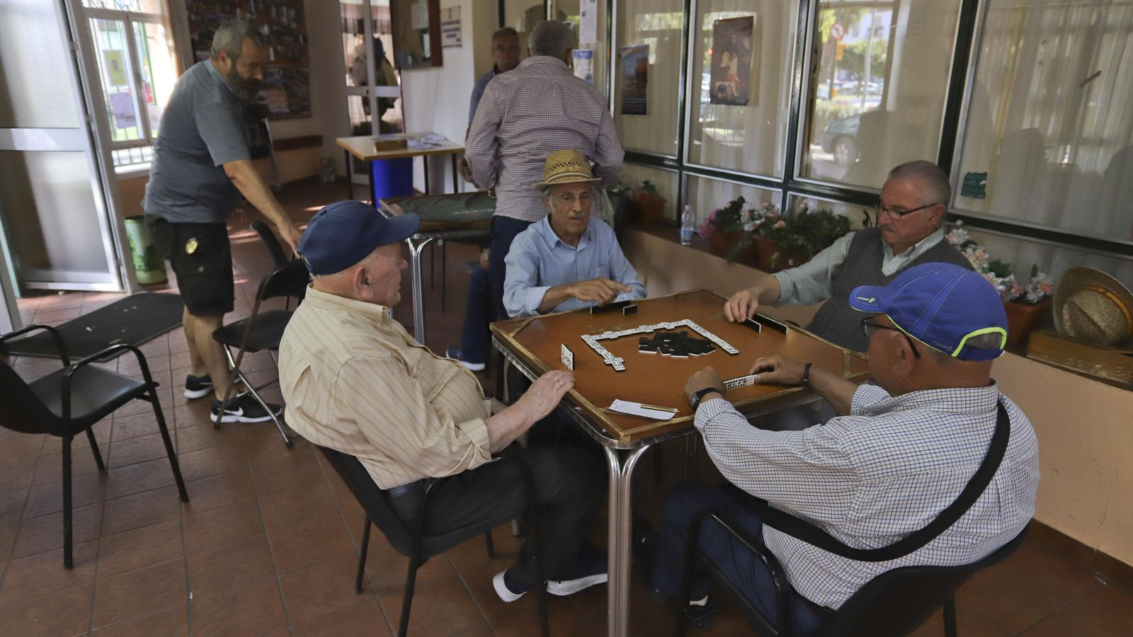 Varias personas mayores juegan al dominó en un hogar del jubilado. Varias personas mayores juegan al dominó en un hogar del jubilado.