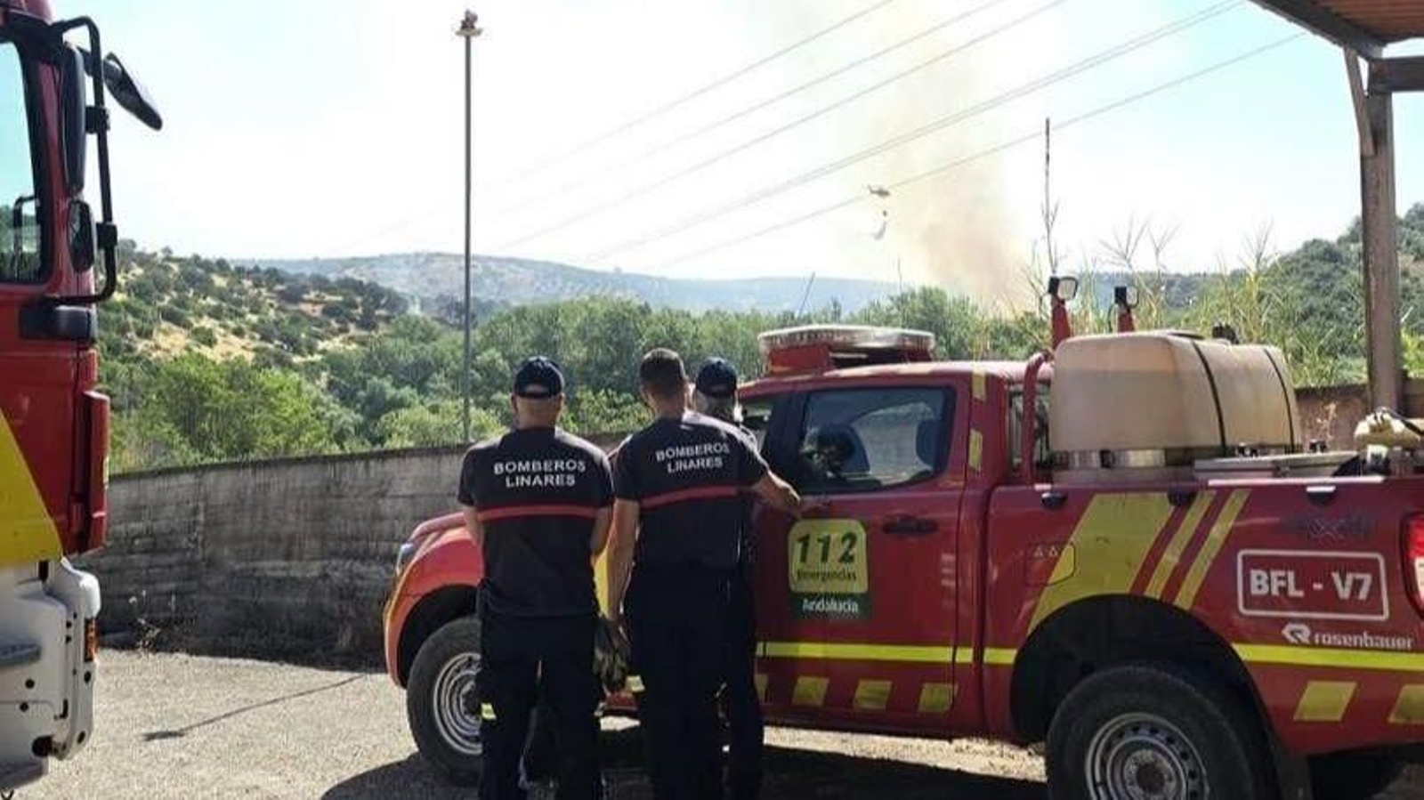 Bomberos de Linares desplazados a Navas de San Juan, mientras un helicóptero descarga agua.