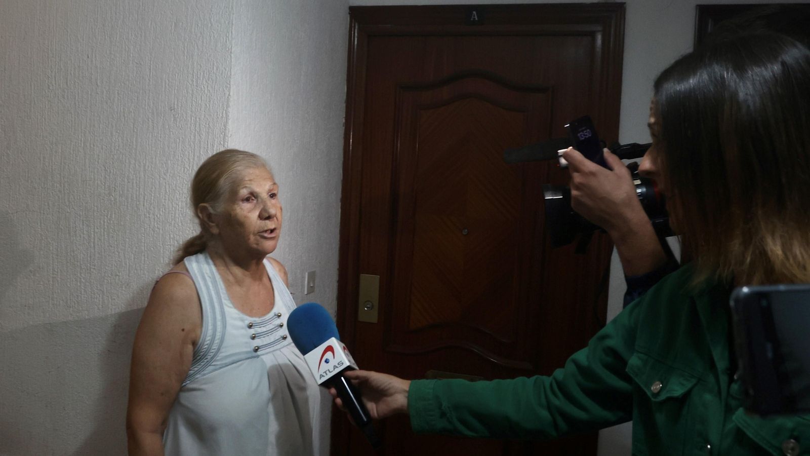Una vecina del bloque donde se produjo el asesinato habla con los periodistas.