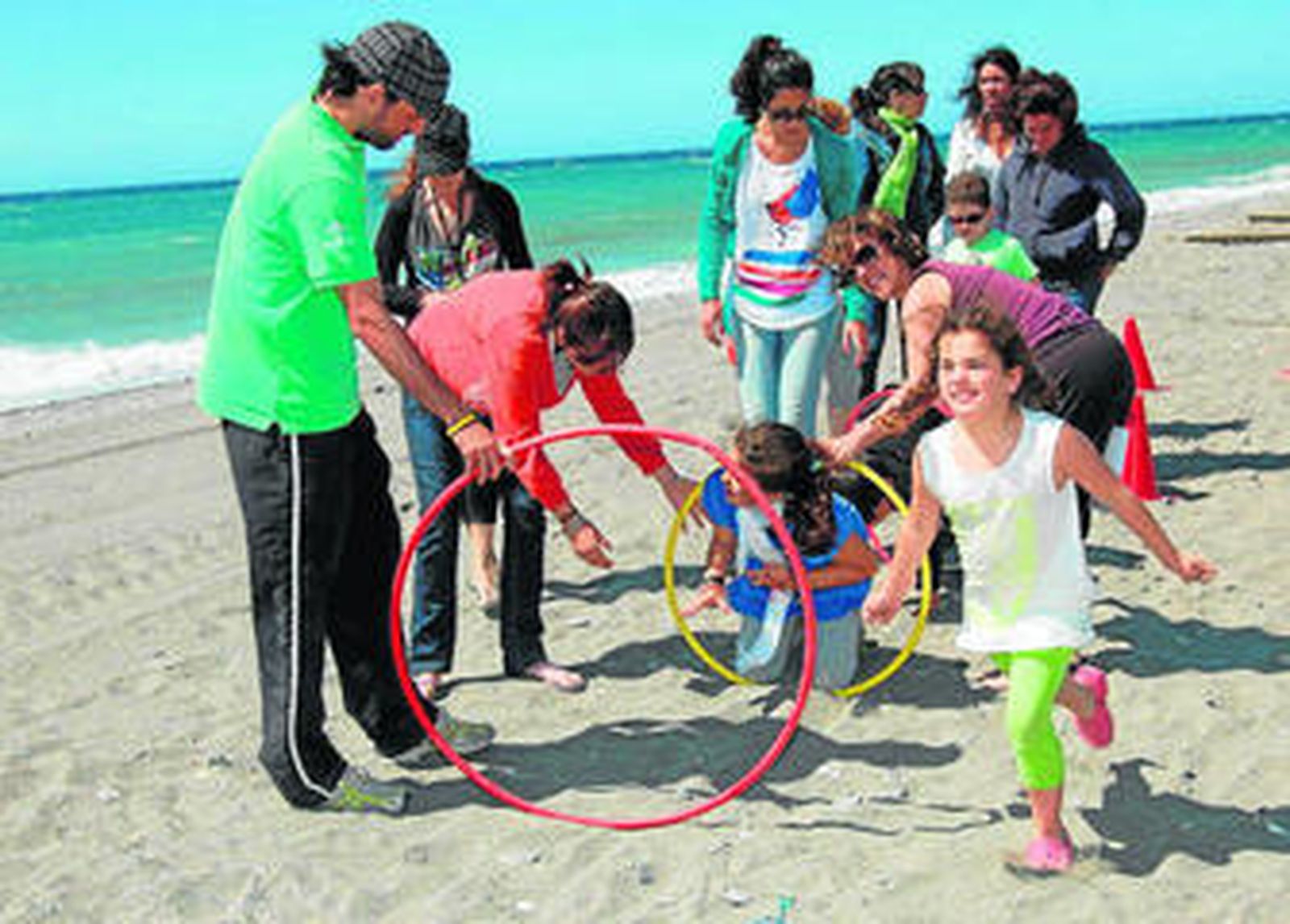 Un grupo de niños y monitores, en la playa.