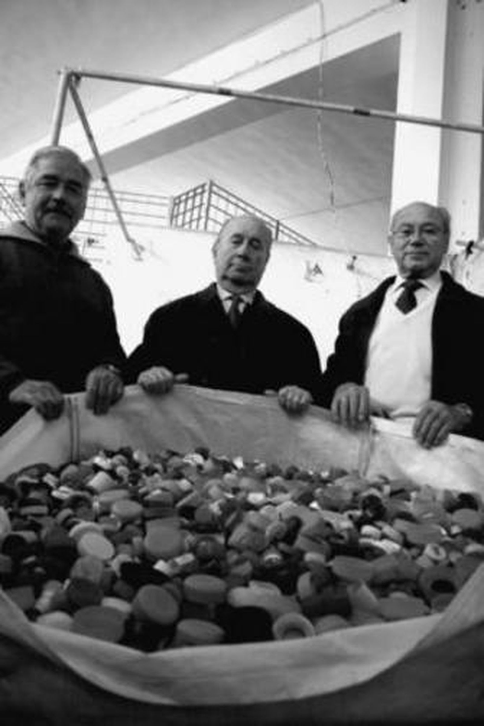 Miembros del Club de Leones muestran un saco de tapones.