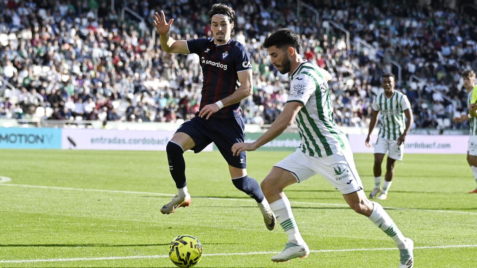 Jacobo intenta sacar un centro ante la oposición de Cubero en el Córdoba CF - Eibar.