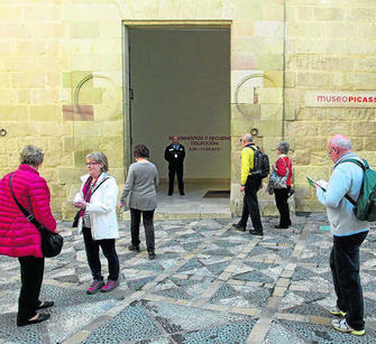 Varios turistas esperan para acceder al Museo Picasso en  Málaga.