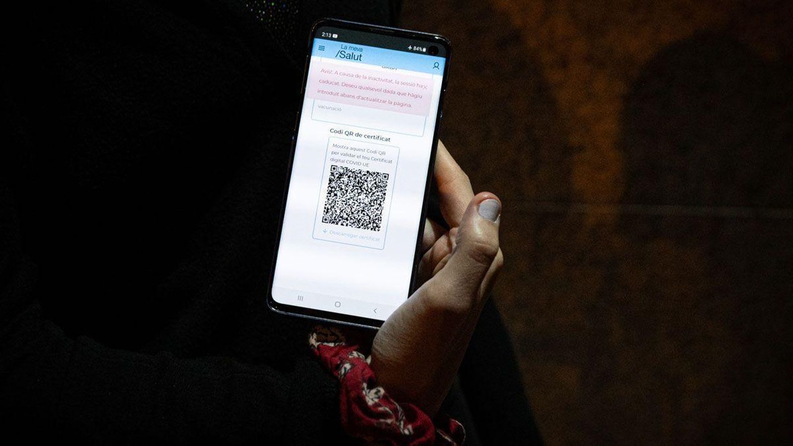 Una mujer muestra el pasaporte covid en su móvil