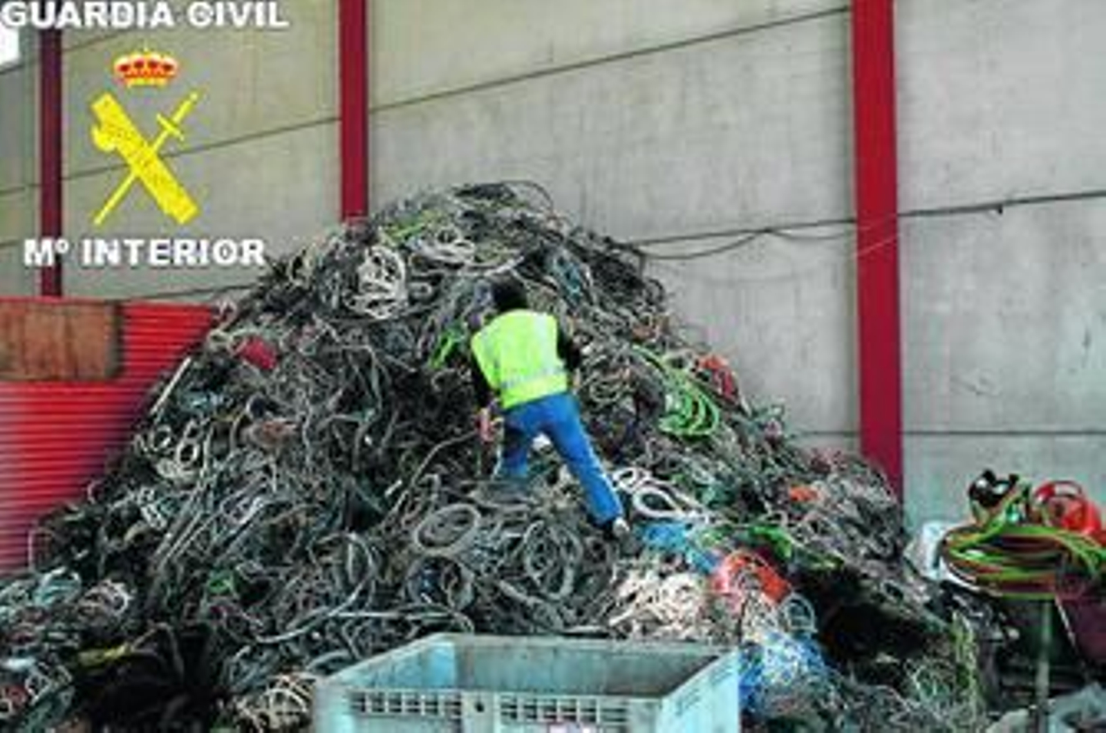 Un guardia civil, subido en una montaña de cobre apilado en una chatarrería de la provincia.