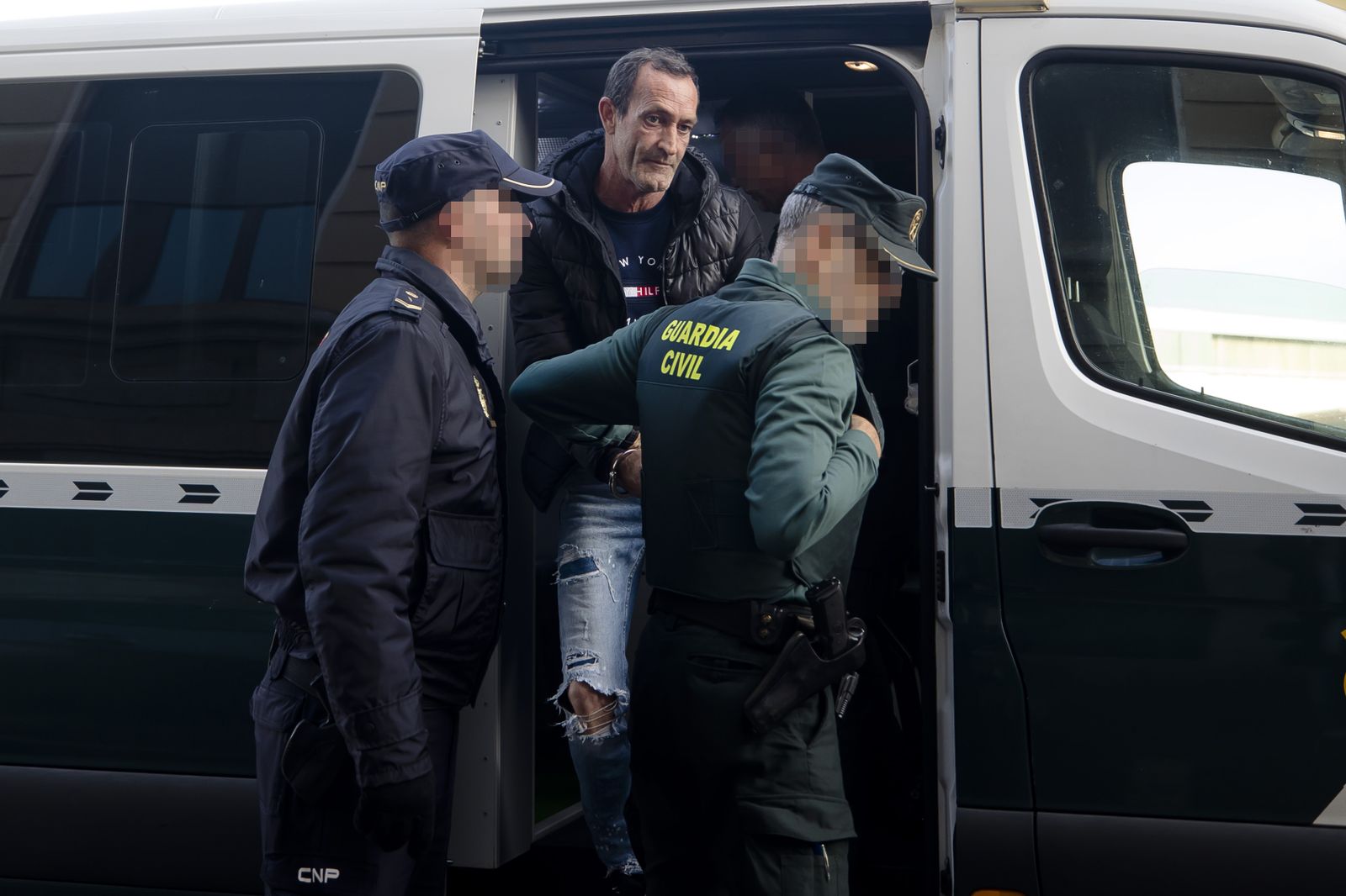 Policía y Guardia Civil custodian al procesado a su salida del furgón.