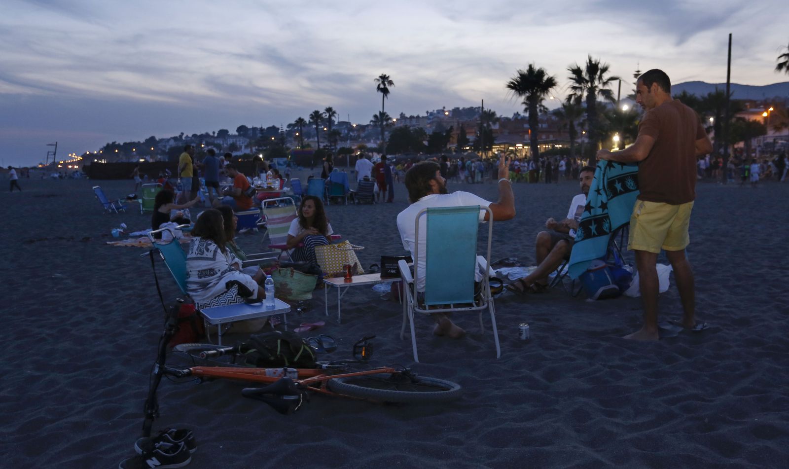 Grupos de amigos y familias inician la velada en la playa.