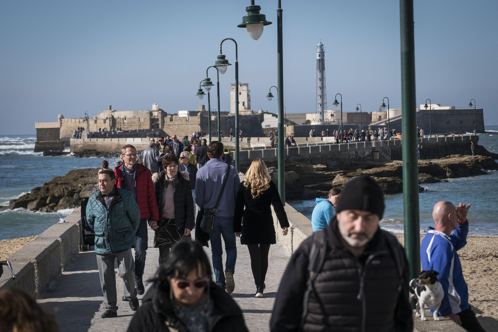 Ciudadanos recorren el Paseo Fernando Quiñones junto a la playa de La Caleta.