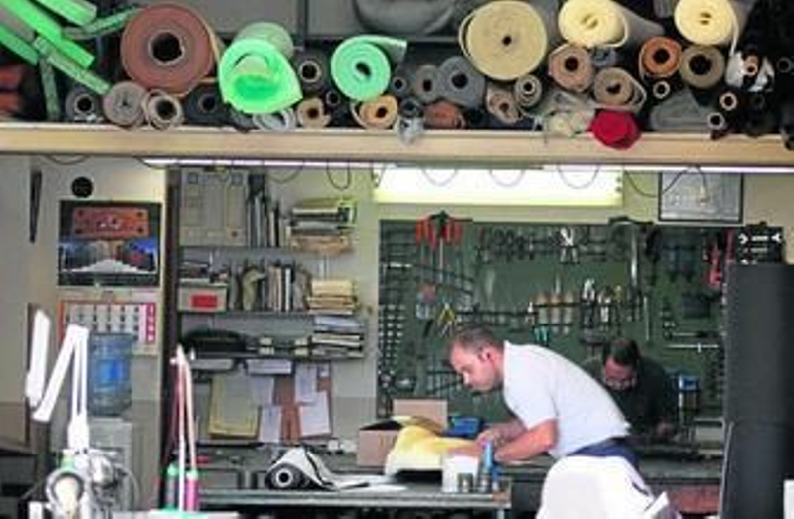 En la página de la izquierda, un trabajador, en una tienda de moquetas. En ésta, de arriba a abajo y de izquierda a derecha, una chimenea que refleja el pasado industrial del barrio, uno de los edificios con una de las arquitecturas más singulares de la zona, el colegio San Juan de Dios Goleta, la bodeguita El Cenachero y la 'herida' del Guadalmedina.