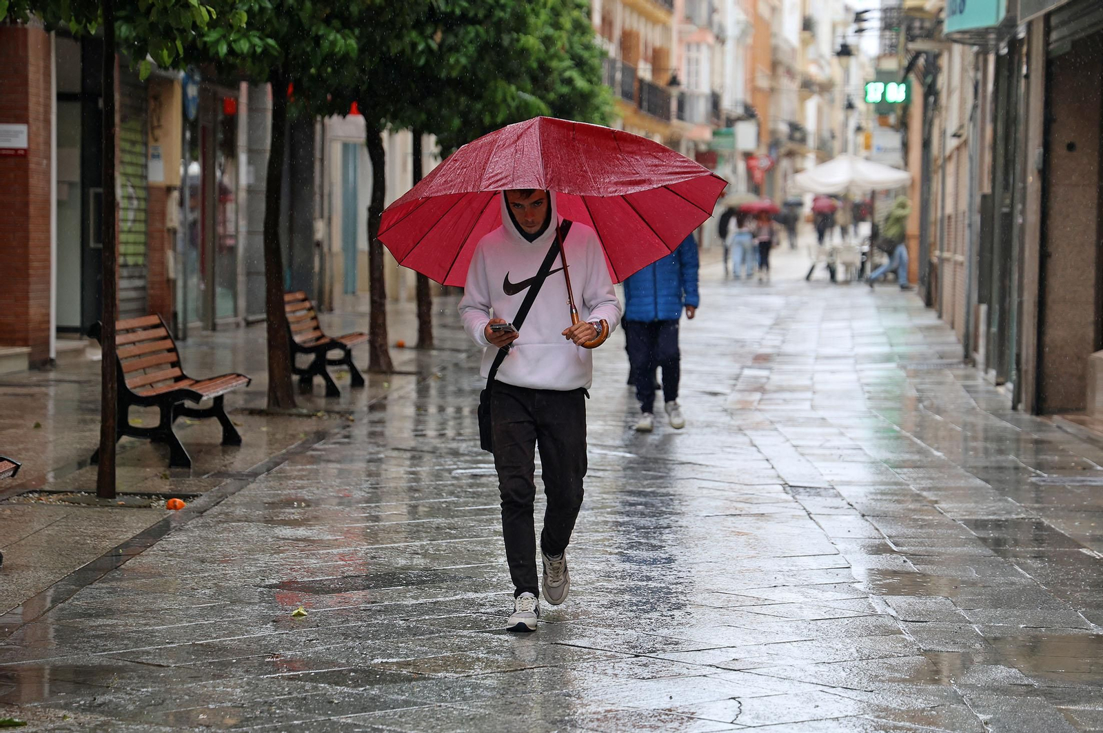 Un joven con su paraguas este viernes en Huelva.