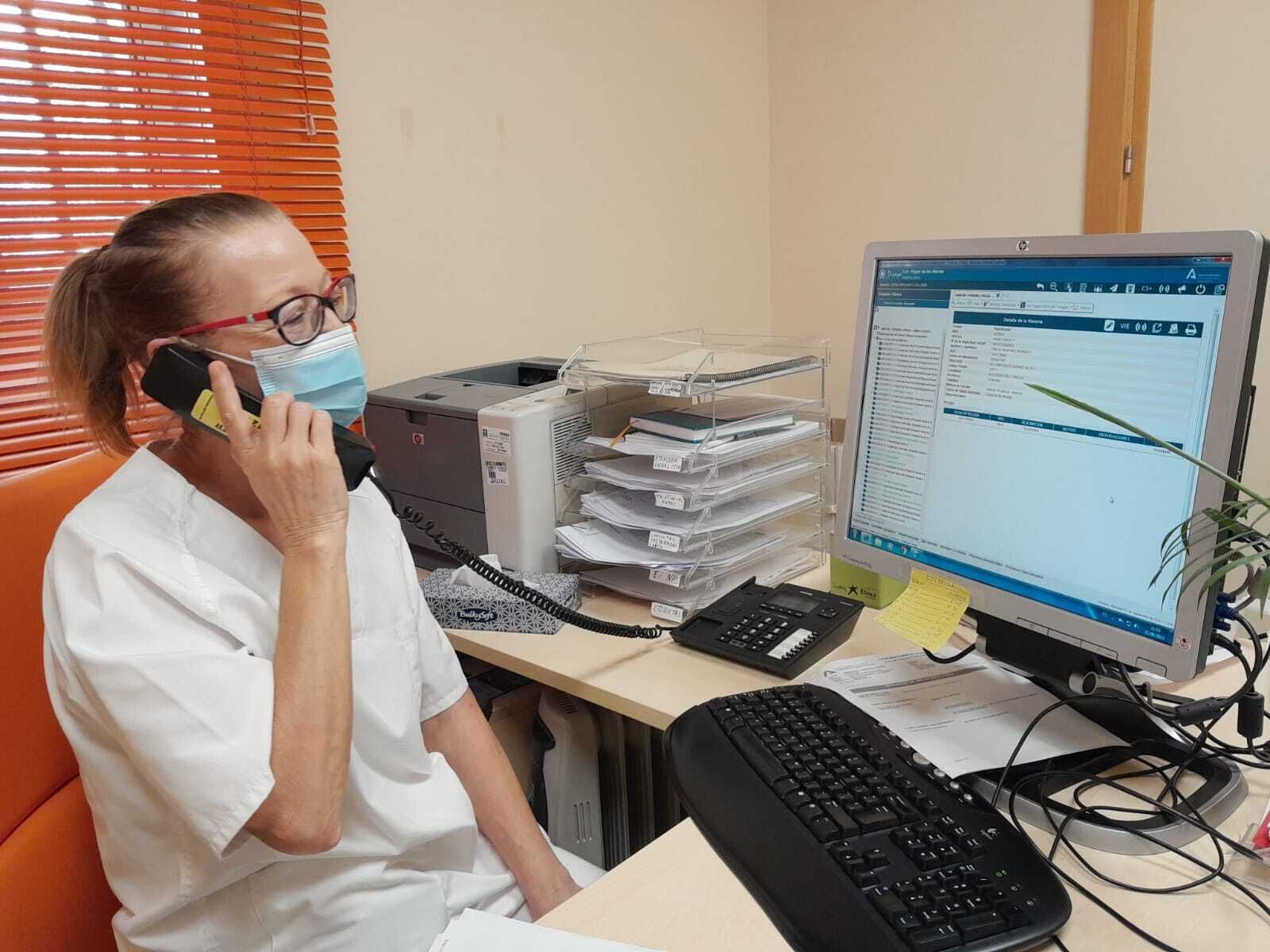 Una trabajadora del hospital atiende por teléfono a un paciente.