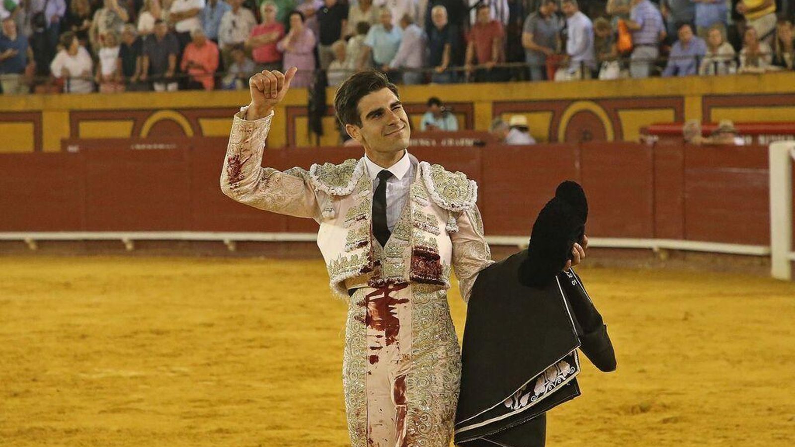 Miguel Ángel Pacheco, vestido de rosa palo y oro.