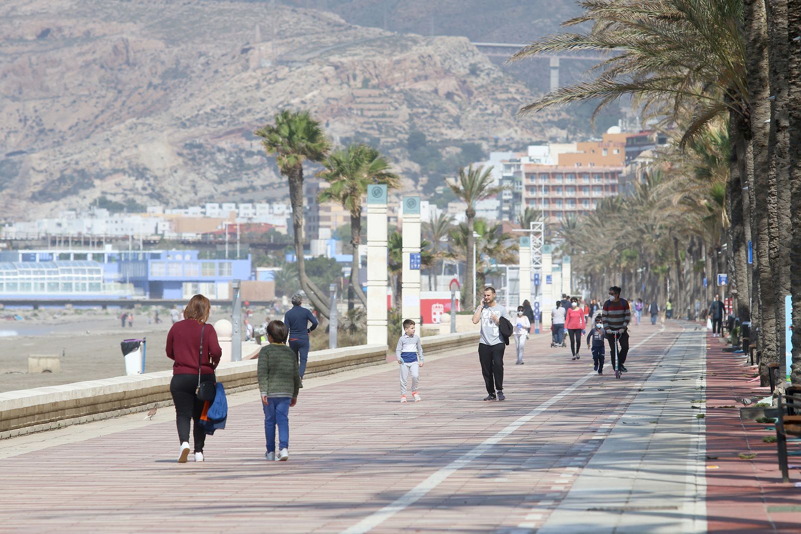 Varias personas pasean por el Paseo Marítimo de la capital almeriense.