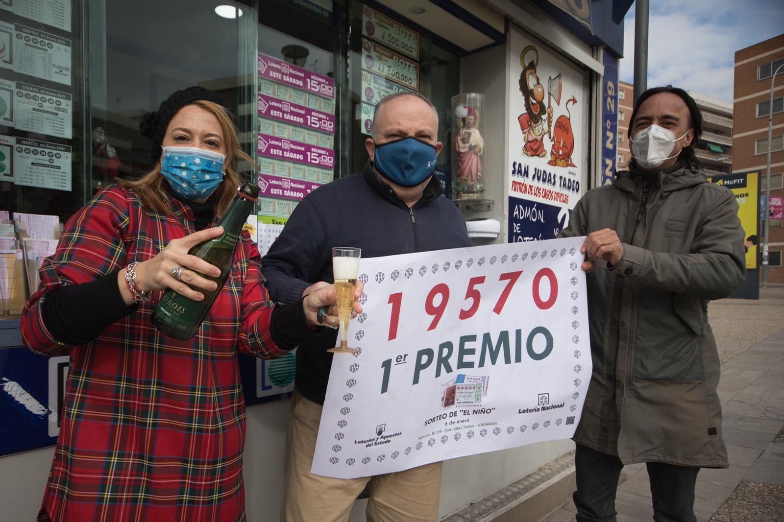 Los gerentes del kiosko de Neptuno, en Granada capital, celebran haber vendido el Primer Premio del Sorteo del Niño.