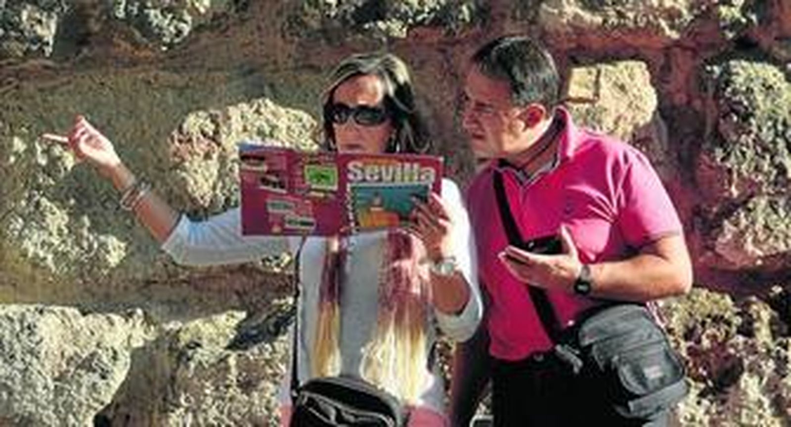 Turistas consultan una guía de Sevilla.