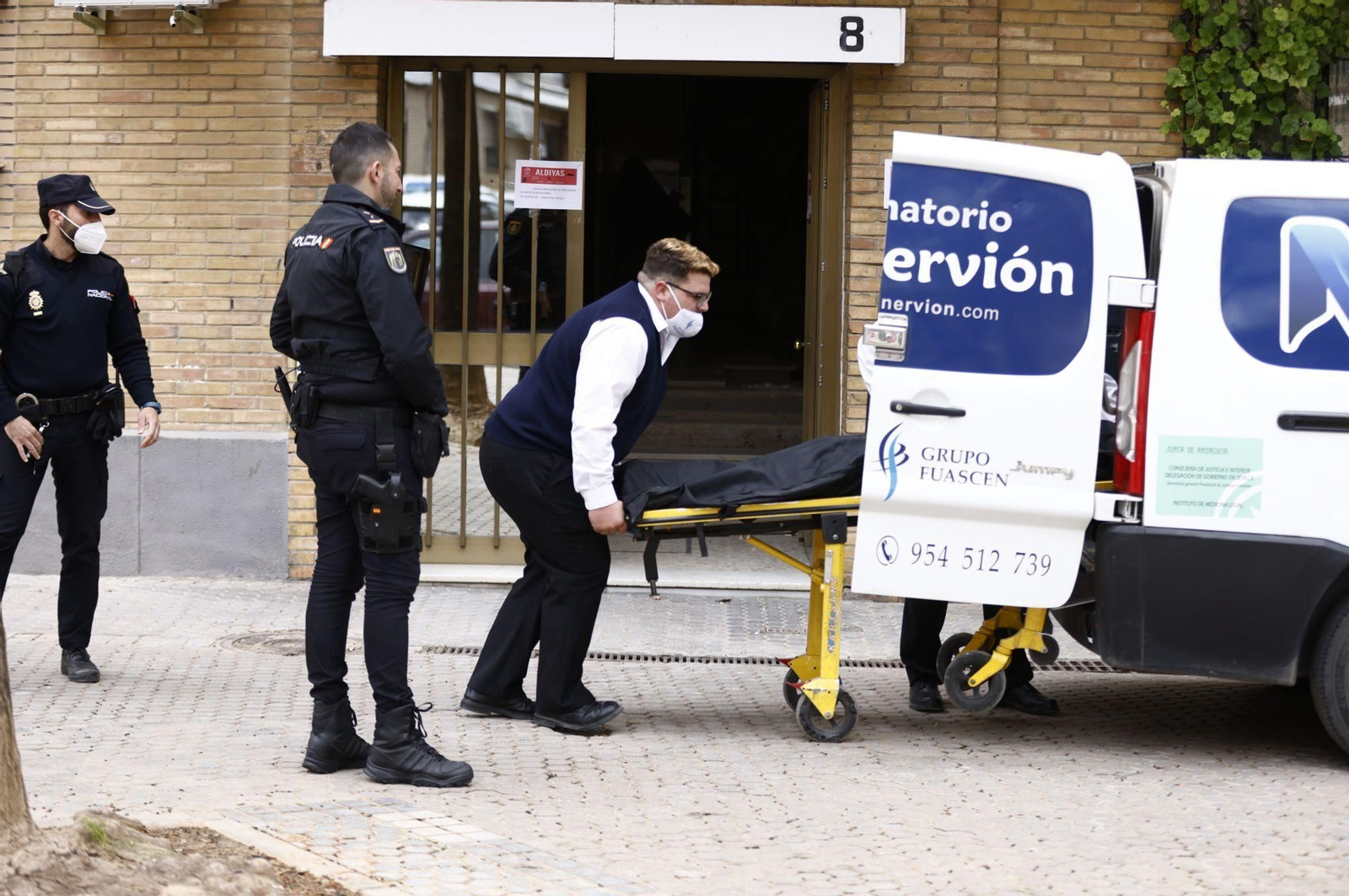 Operarios del tanatorio Nervión retiran uno de los cadáveres de las hermanas.