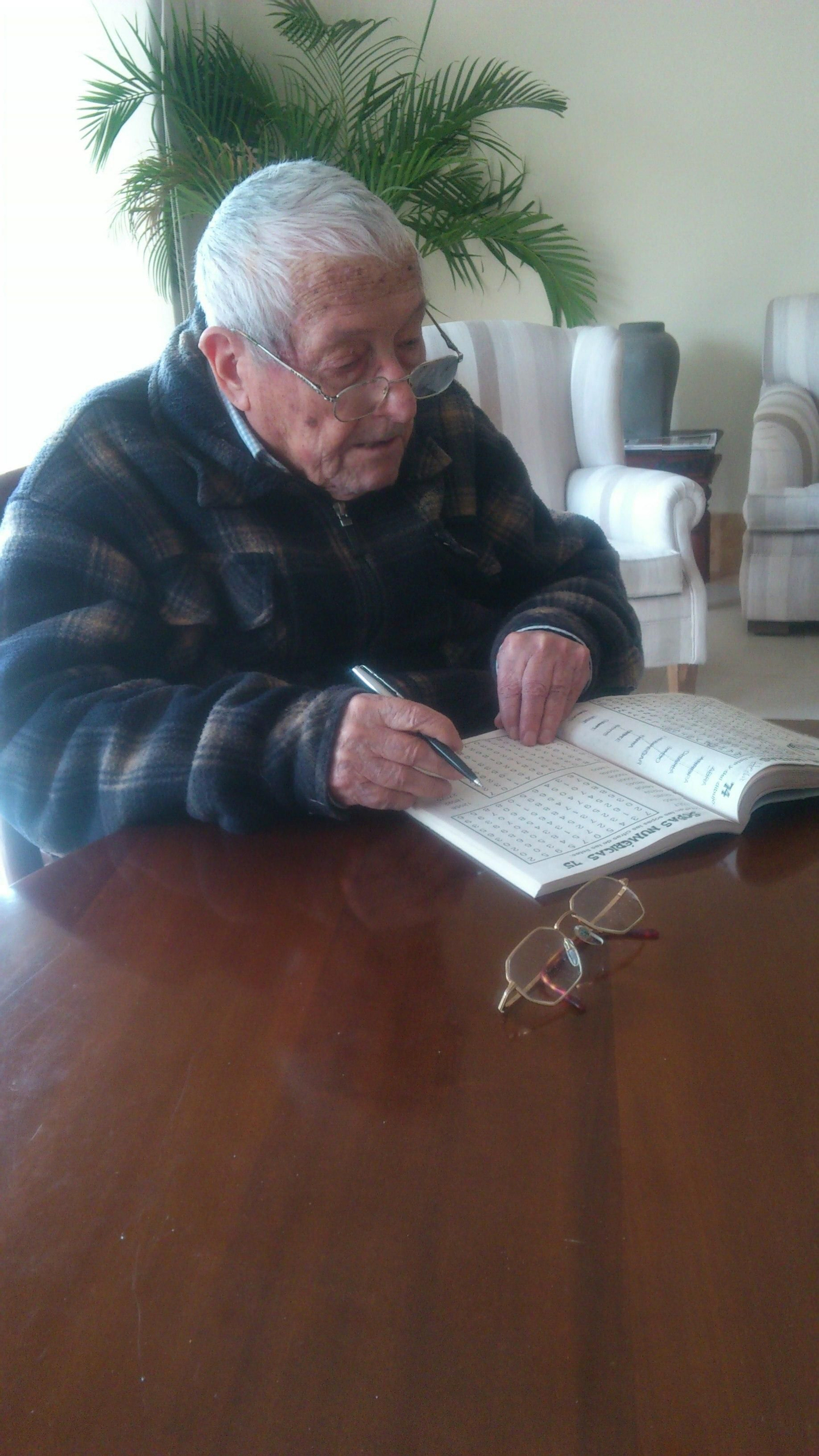 Tito Pedro haciendo un crucigrama en una sala de la residencia antes de una entrevista con este diario.