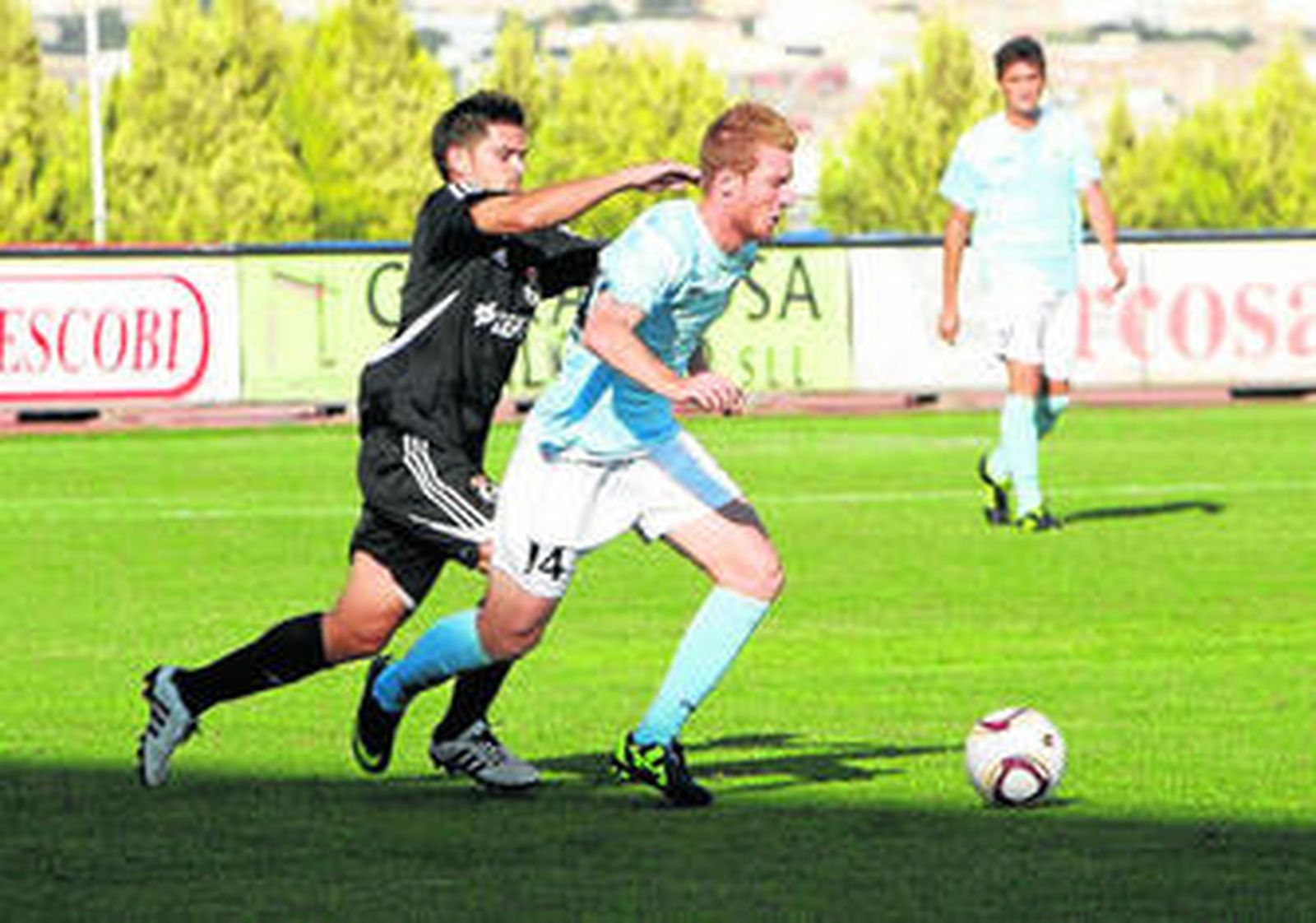 Ximo Forner conduce el balón perseguido por Ocaña en el Poli Ejido-Balona de esta misma campaña.