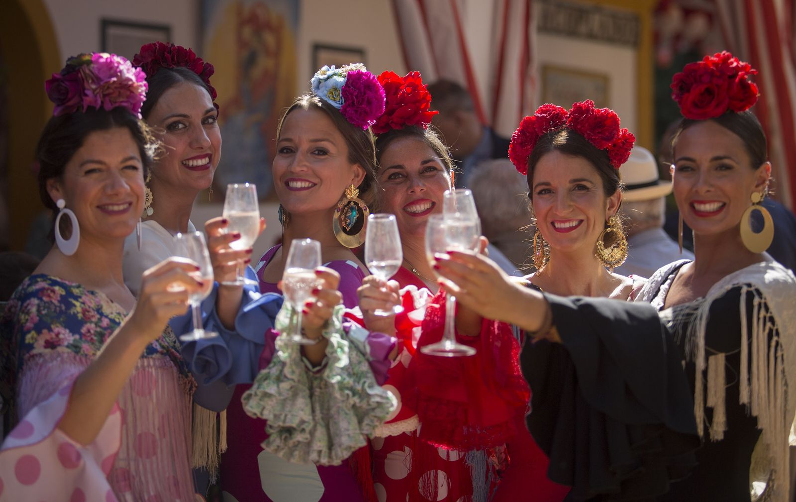 Un grupo de jóvenes brindan con manzanilla en el real de la Feria.