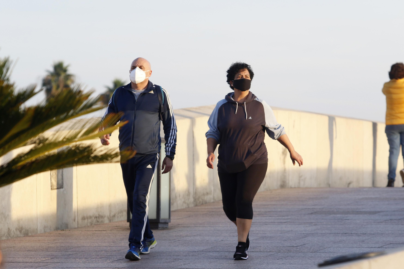 Dos personas caminan por el Puente Romano de Córdoba.