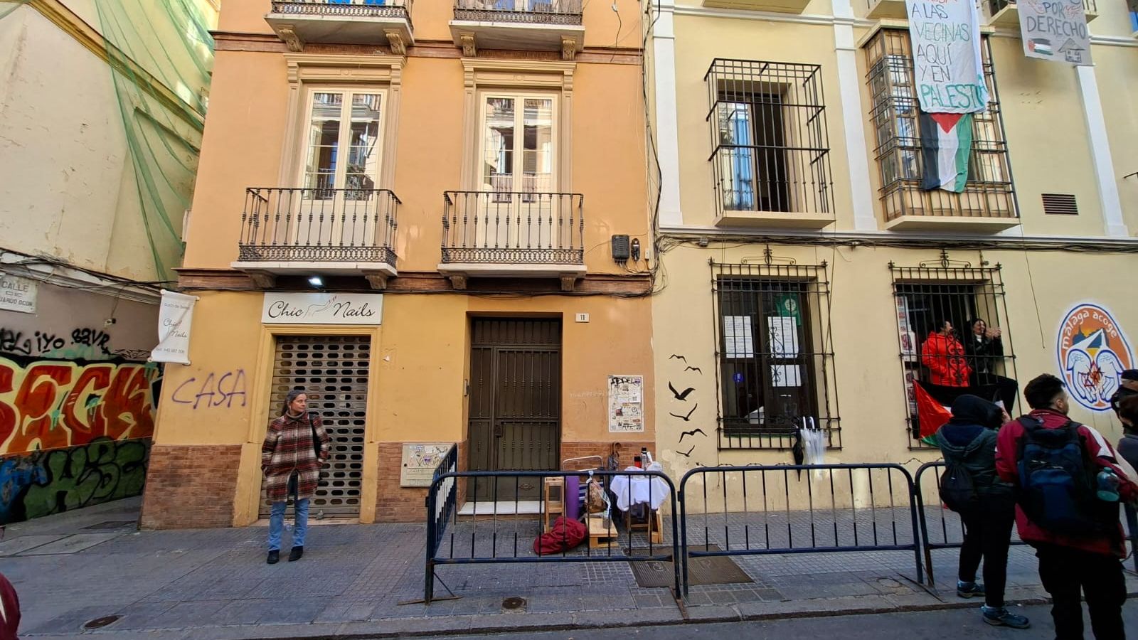 Valla colocada por la Policía ante la puerta del edificio.