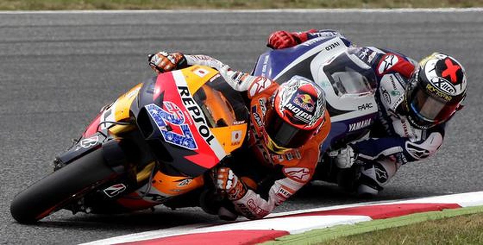 Lorenzo se acerca a Stoner en una curva. / Reuters